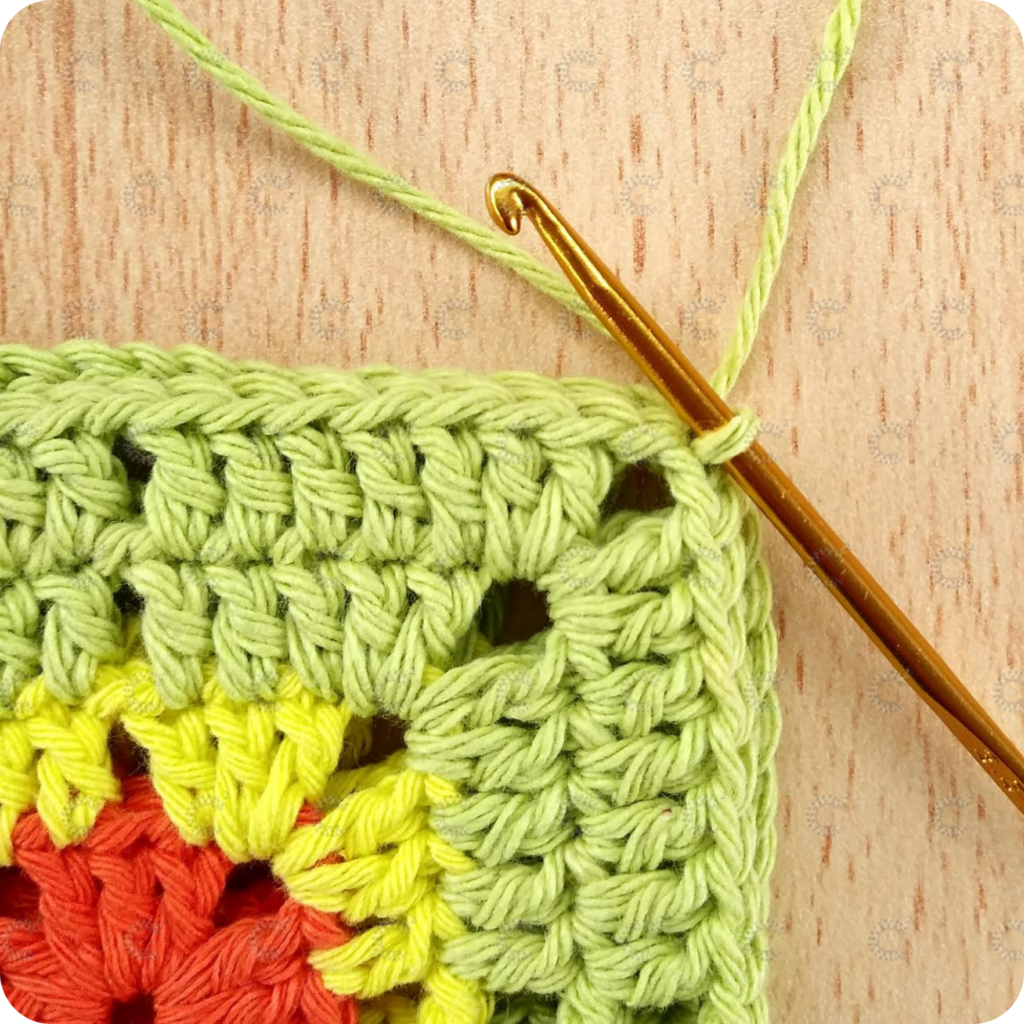 Primer punto enano tejido para unir dos cuadrados al crochet tomando las lazadas internas