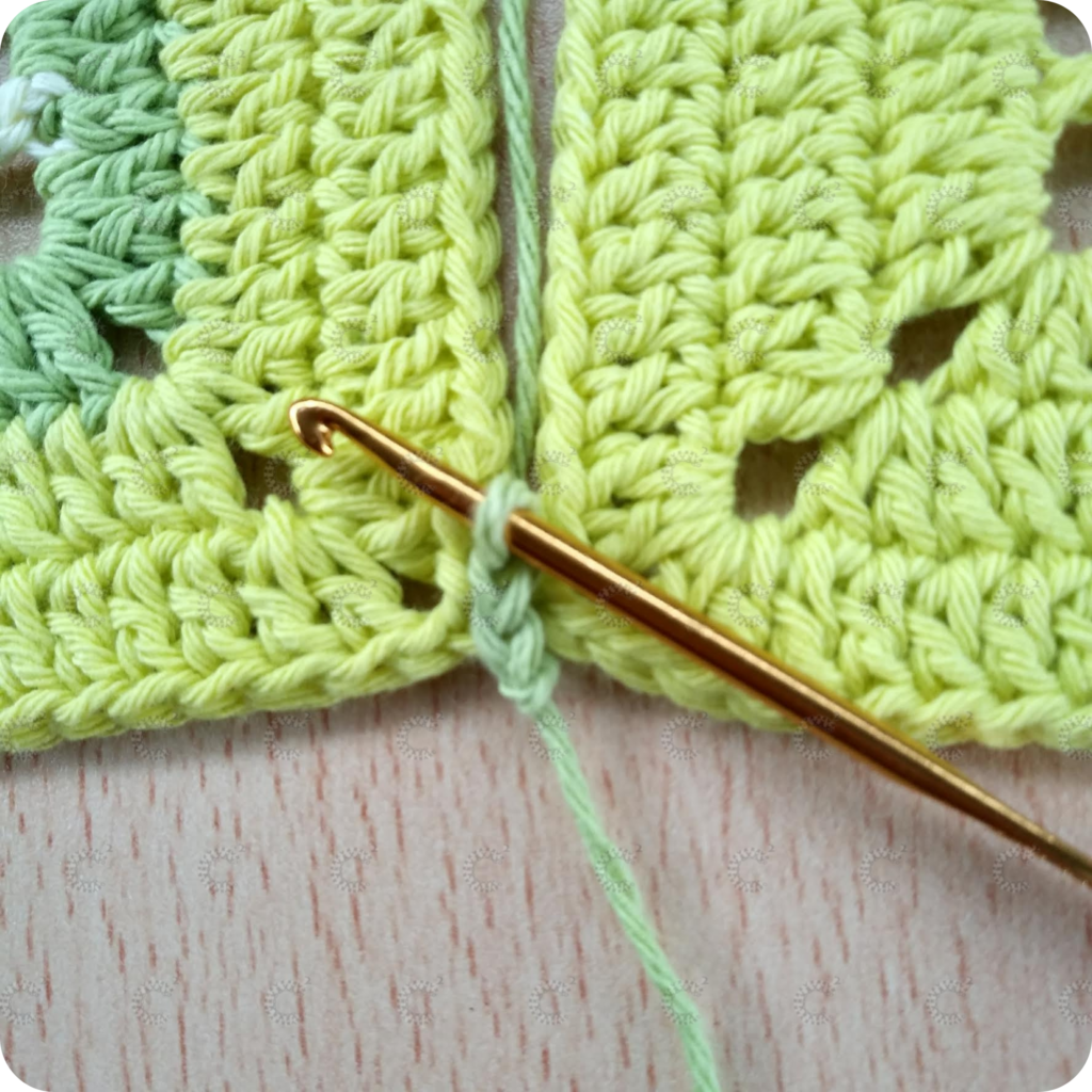 Unión de cuadrados al crochet terminada con aguja de crochet y punto enano plano