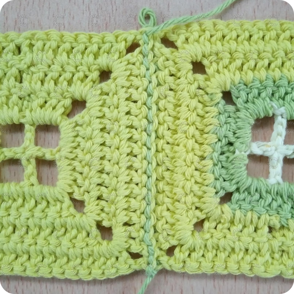 Revés de la unión de cuadrados al crochet sin relieve con hilo contrastante, puntadas prolijas