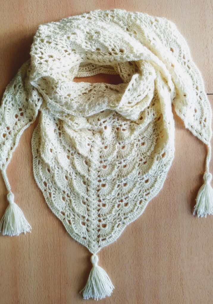 Chal triangular al crochet finalizado con borlas decorativas