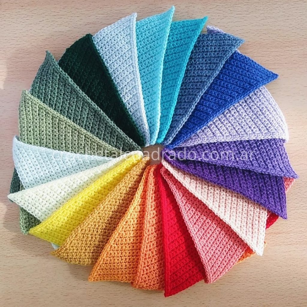 Banderines triangulares tejidos al crochet en colores pastel dispuestos en forma circular